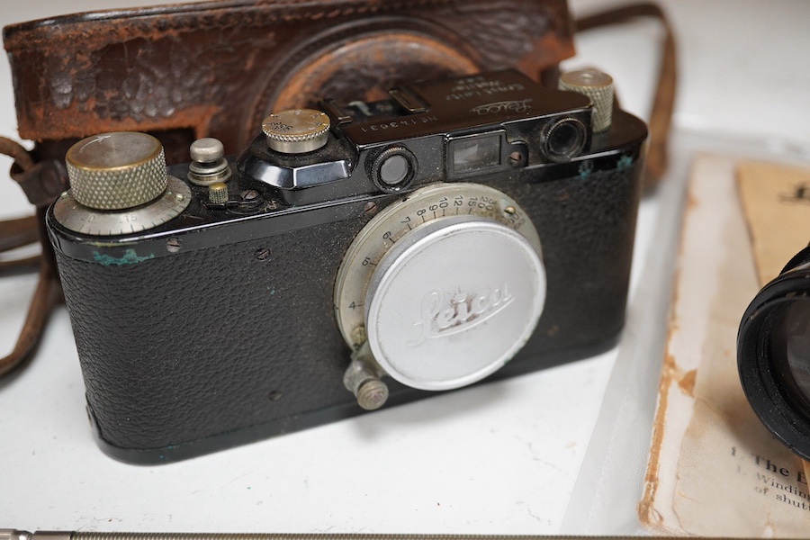 A Leica Model II camera in leather case, together with an Elmar 4.5/135mm lens, lens table booklet and instruction booklet. Condition - poor to fair.